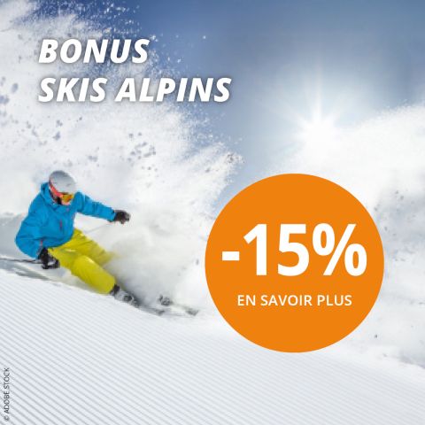 Un skieur en veste bleue et pantalon jaune dévale une pente dans la neige fraîche. Le texte indique "BONUS SKIS ALPINS" et un cercle orange avec "-15% EN SAVOIR PLUS" offre une réduction de 15%.