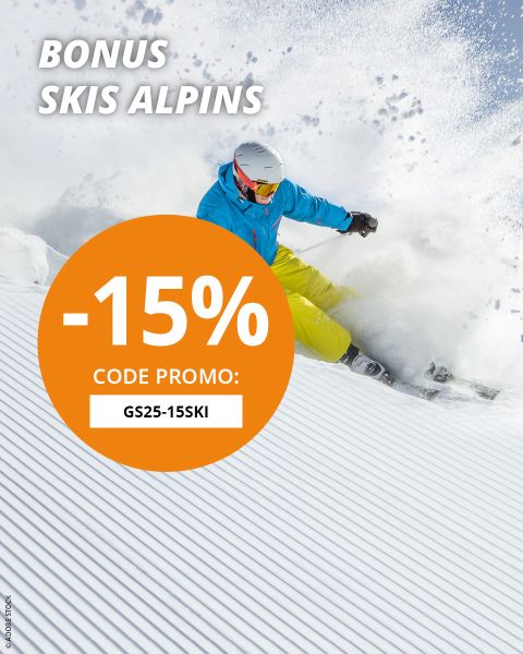 Un skieur en veste bleue et pantalon jaune fait du ski dans la neige fraîche. Le texte superposé offre 15 % de réduction sur les skis alpins avec le code promotionnel GS25-15SKI.