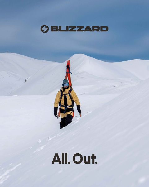 Deux skieurs en tenue d'hiver dévalent une pente enneigée. Le skieur de gauche porte une tenue rose, celui de droite une tenue beige. Les deux portent des casques et des lunettes de protection. Le logo Blizzard est visible en haut à gauche.