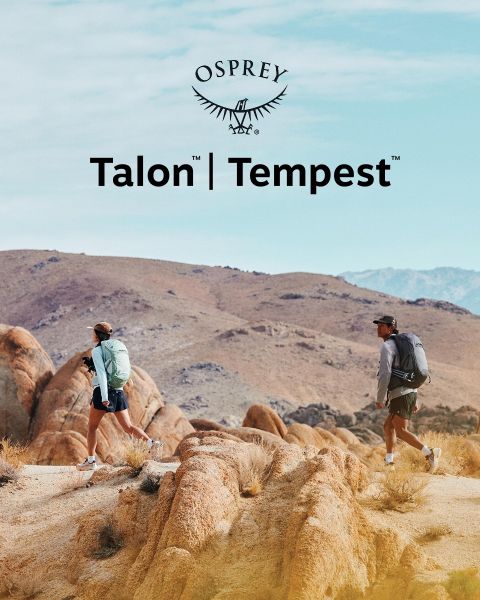 Une personne descend un terrain rocheux avec un sac à dos vert, un bonnet noir et des vêtements sombres. La lumière du soleil illumine le paysage. Au premier plan, on peut voir le logo Osprey.
