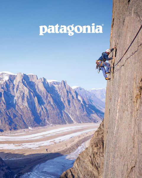 Deux grimpeurs se reposent sur un rebord rocheux. Leur équipement d'escalade est éparpillé autour d'eux. L'un porte une veste bleue, l'autre une veste rose. À l'arrière-plan, on aperçoit une vallée boisée pittoresque. En haut, on peut lire le mot « Patagonie ».