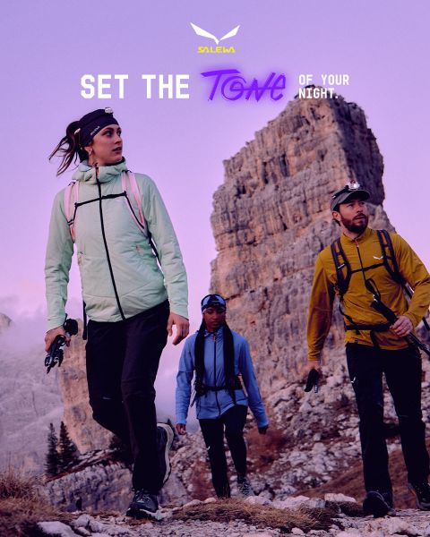 Une personne en veste blanche et lunettes de soleil escalade un terrain rocheux. L'effet de flou de mouvement accentue la vitesse et le mouvement. En haut, on peut lire le texte « MXT Forward A Fast Story », et à droite le logo Salewa.