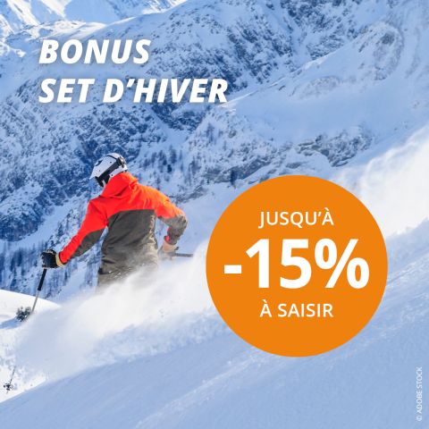 Un skieur en veste orange dévale une pente enneigée. Le texte indique "BONUS SET D'HIVER" et dans un grand cercle orange, on peut lire "JUSQU'À -20% À SAISIR". En arrière-plan, on aperçoit des sommets enneigés.