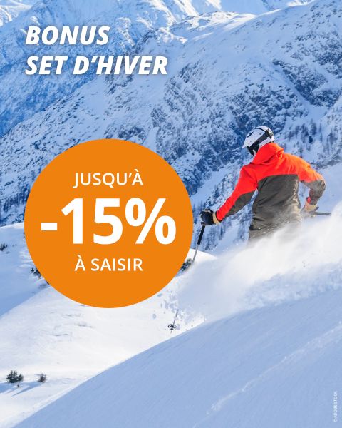 Un skieur en veste orange et casque dévale une montagne enneigée avec des pins. Le texte en gras fait la promotion d'un bonus d'ensemble d'hiver et d'une réduction allant jusqu'à 20 %. En arrière-plan, on aperçoit des sommets enneigés.