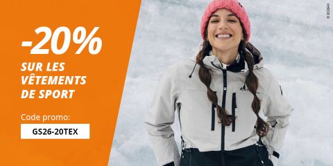 Une femme souriante en vêtements de sports d'hiver et bonnet rose se tient dans la neige à côté d'un texte offrant 20 % de réduction sur les vêtements de sport avec le code promotionnel GS26-20TEX.