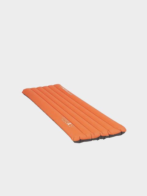Un matelas de sol gonflable turquoise avec des rainures horizontales sur un fond gris clair. En haut, le mot « ISOMATTEN » est écrit en grandes lettres blanches.