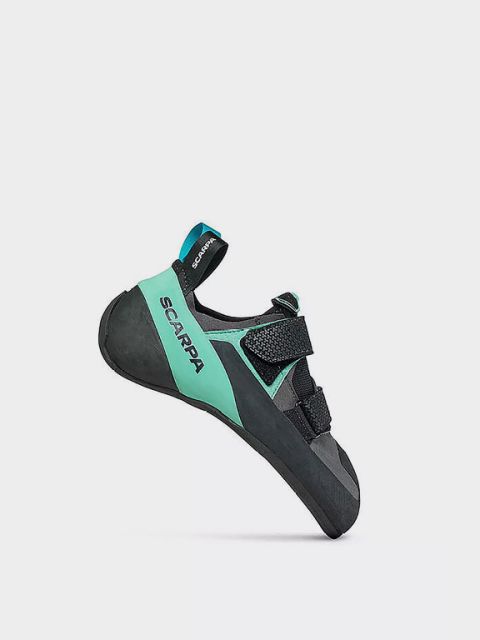 Chaussure d'escalade orange et noire avec fermeture velcro et semelle texturée. Le mot « KLETTERSCHUHE » est écrit en gras en blanc dans le coin supérieur gauche. L'arrière-plan est uni et blanc.