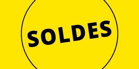 Fond jaune avec un cercle noir et le mot "SOLDES" en gras noir au centre, indiquant des soldes ou des réductions.