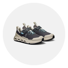 Une paire de chaussures de sport noires et beiges avec des accents bleus, des fermetures velcro et des semelles épaisses, représentée sur un fond blanc.