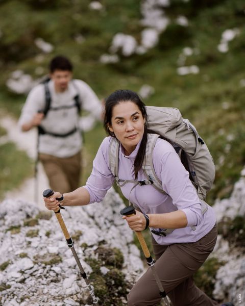 Deux images sur fond de bois montrent un modèle féminin et un modèle masculin portant des vêtements de randonnée d'extérieur. Le modèle féminin porte une tenue rose et verte, le modèle masculin une tenue verte et tient des bâtons de trekking à la main. Texte : « TYPE EXTÉRIEUR RANDONNEUR ACTIF ».