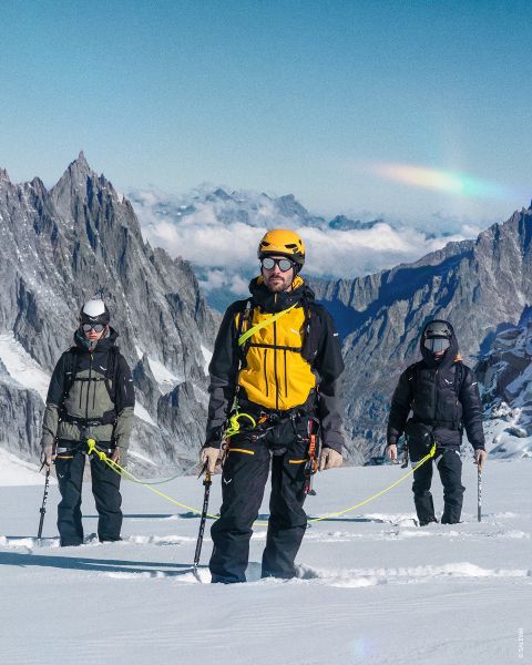 Deux images sur fond rocheux. À gauche : femme en tenue de randonnée violette avec casque. À droite : personne en tenue vert et bleu avec sac à dos jaune, équipement d'escalade et corde enroulée. Texte : « TYPE OUTDOOR ALPINISTE ».