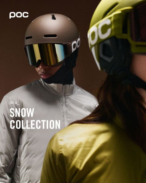 Une personne portant un manteau d'hiver orange et un casque se tient au sommet d'une montagne enneigée et regarde les montagnes enneigées au loin. Le logo POC est visible sur le casque et dans le coin supérieur droit de l'image.