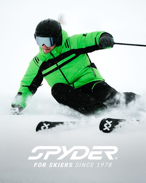 Un skieur en tenue noire et jaune dévale une pente enneigée, avec un paysage enneigé en arrière-plan. En haut, le texte indique : « SPYDER POUR LES SKIEURS DEPUIS 1978 ». Un petit logo d'araignée blanche est visible dans le coin inférieur droit.